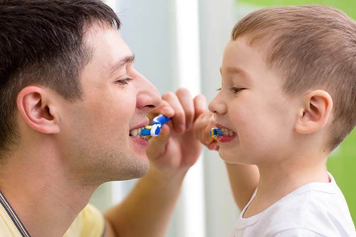 Father and son brushing their teeth